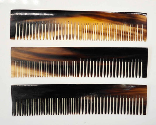 Three Cathcart Elliot handmade 6-inch combs, crafted from real ox horn, display a brown and black tortoiseshell pattern on a white background. Each personalized piece features unique variations and finely spaced teeth.