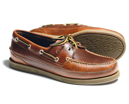 The Orca Bay FOWEY Mens wide-fitting deck shoe in saddle brown features premium leather with tan laces, beige slip-resistant patterned soles, white stitching, and metal eyelets.