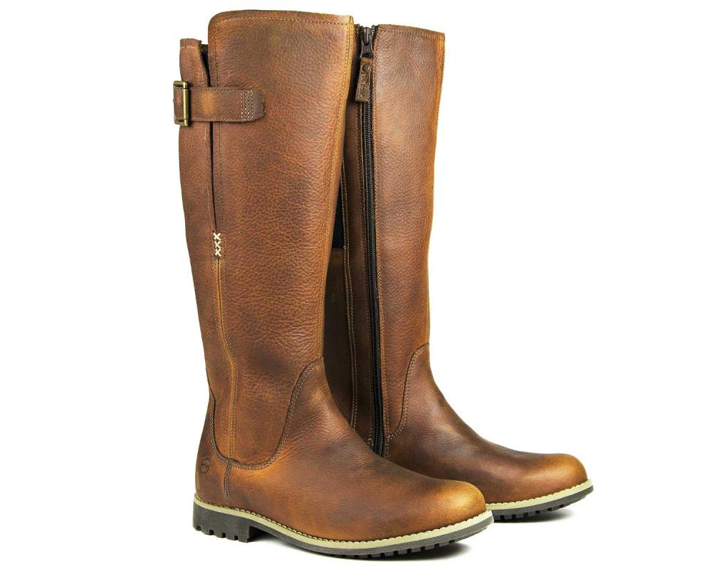 Discover the SALE Ladies Moreton Tall Boot by Orca Bay, expertly crafted from luxurious Havana Leather. These brown boots boast side zippers, a top buckle strap, and a durable winter sole with patterned tread for enhanced grip—a perfect blend of style and function.