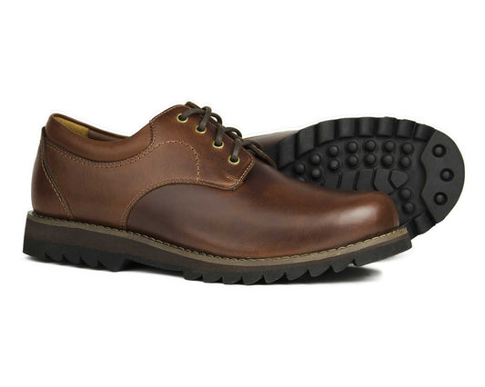 This Orca Bay BILBURY Mens Brown Leather Country Derby Shoe features rugged rubber soles and an EVA mid-sole. One shoe stands upright while the other lies on its side, displaying the tread pattern. With a smooth finish and dark stitching, they add sophistication to any outfit.