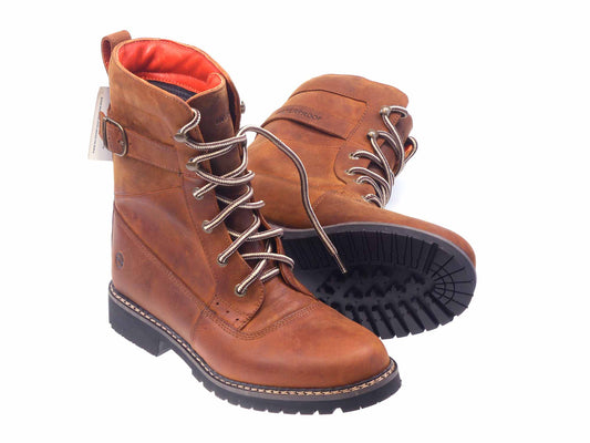 The Bodmin Ladies Waterproof boot by Orca Bay features brown leather, lace-up design, and durable rubber soles. One boot stands upright highlighting its buckle detail, while the other lies on its side showing the textured sole. Ideal for adventurous women seeking style and durability.