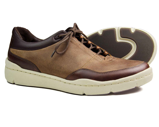 The SALE CAMDEN Mens Brown Sneakers by Orca Bay feature leather uppers with dark brown accents, a light textured sole for grip, and lace-up closure. Positioned next to another shoe, they showcase the tread pattern, ideal for fans of mens brown sneakers.