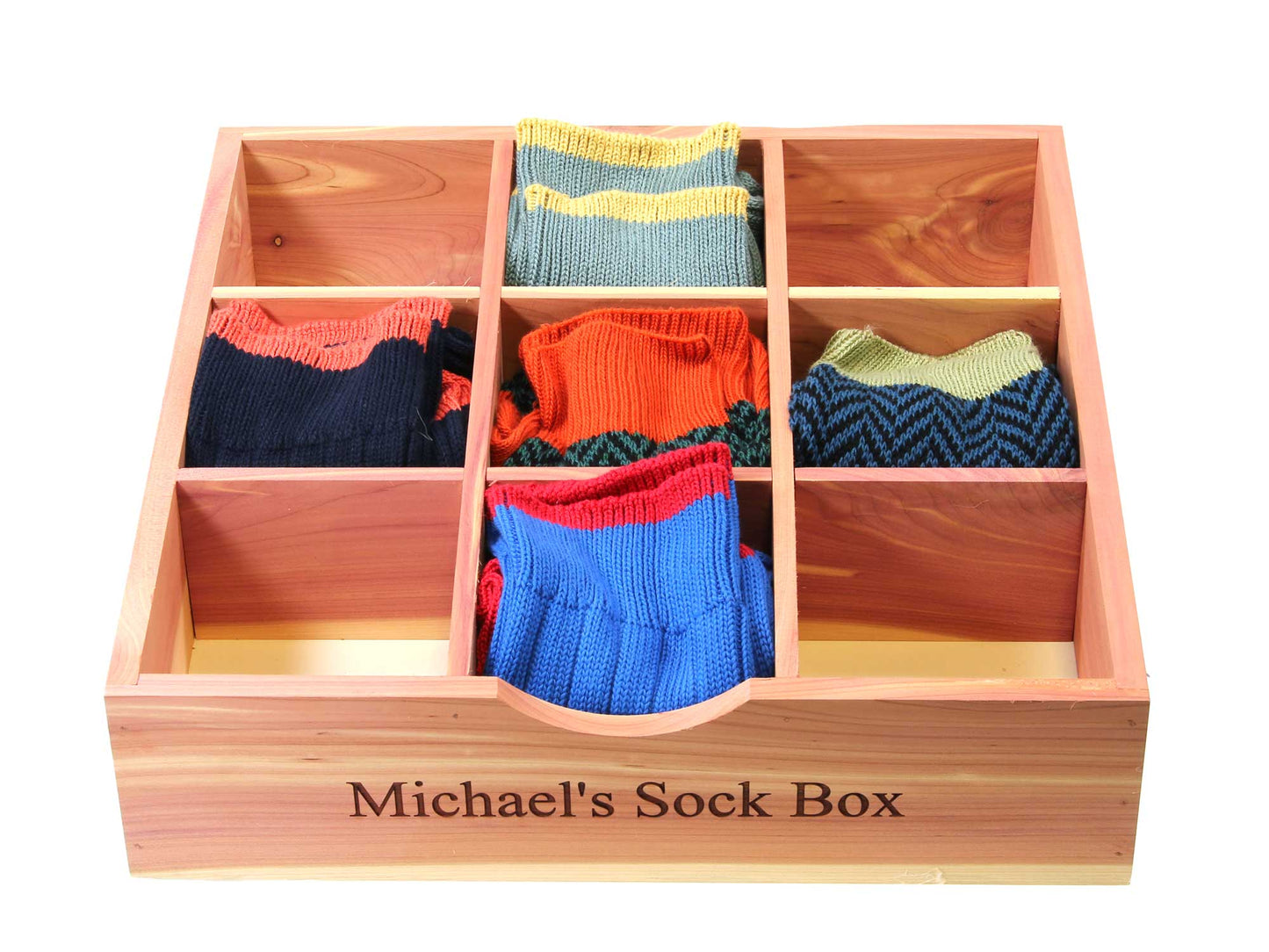 The Cathcart Elliot 31cm x 31cm Cedar Wood Sock and Tie Organiser Michaels Sock Box features six compartments, each holding colorful socks in blue, red, orange, green, and striped patterns. It offers natural moth repellent properties with the elegance of personalized engraving.