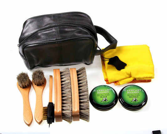 The Cathcart Elliot Shoe Shine Kit includes suede and other brushes, black and neutral wax polish tins, a yellow cloth, and extra brush heads—all in a sleek leather pouch for easy leather shoe care.