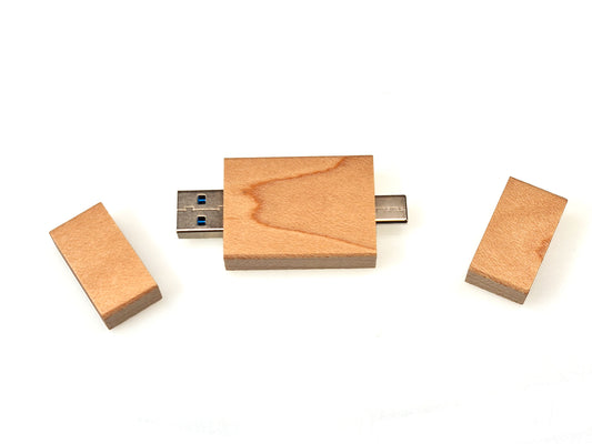 The Personalised Wood Double Ended USB 3 USB C Flash Drive 16GB by Cathcart Elliot is displayed with its cap off, exposing the USB connector. A spare wooden block accompanies it against a white backdrop.