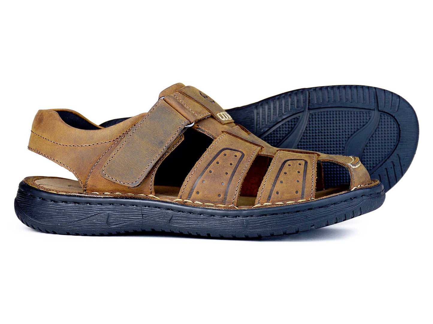 The GRENADA Mens Sandal in Sand Nubuck by Orca Bay features a closed toe, hook-and-loop straps, and a comfy cushioned footbed. Its non-marking rubber sole has a textured pattern for comfort and outdoor use.