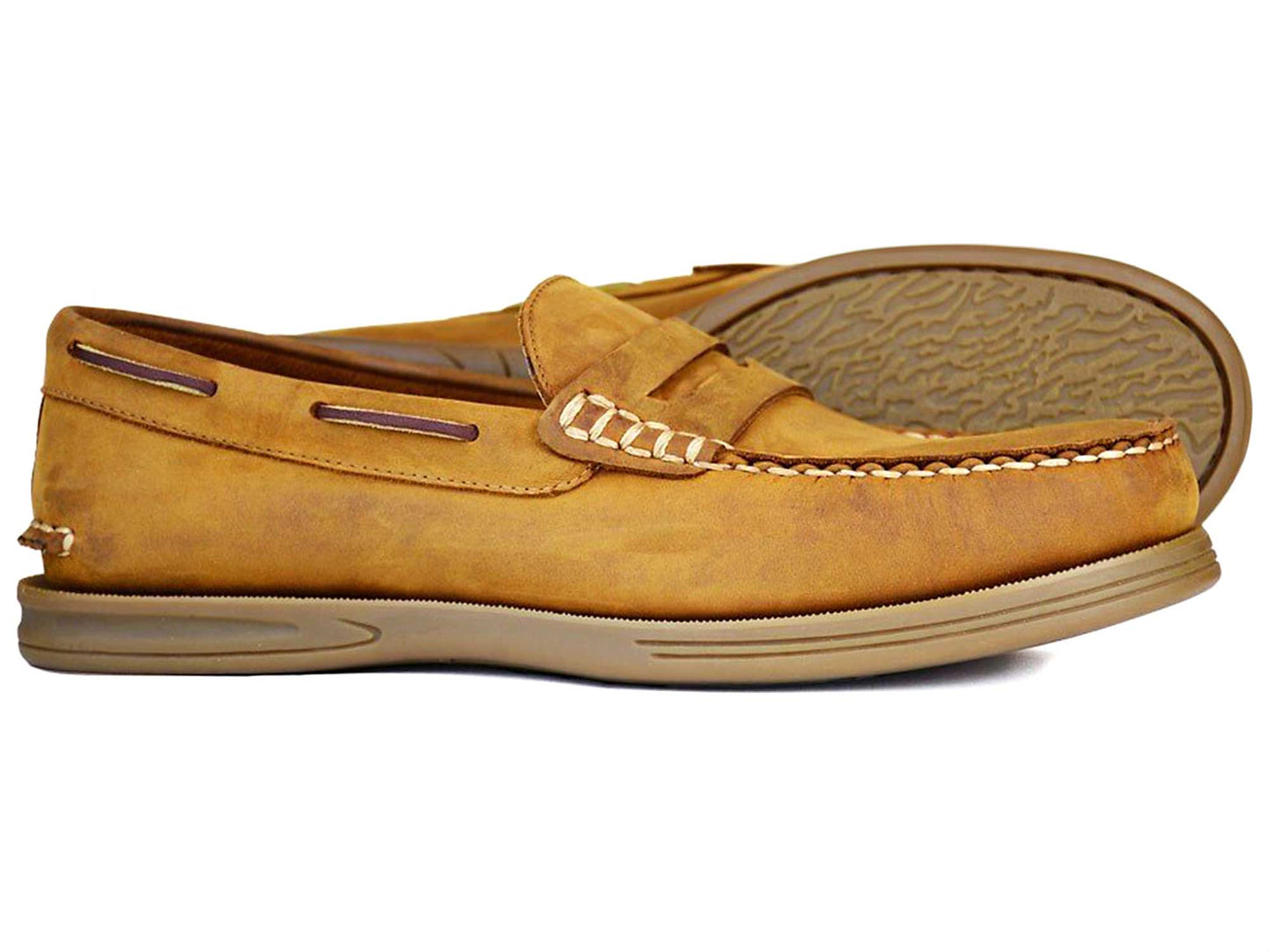 The Orca Bay KIP Mens Deck Shoe in sand nubuck features handstitched details and a penny slot design. It includes a light brown non-slip rubber sole with a textured grip pattern, while the subtly worn finish of the nubuck leather gives it a rustic charm.