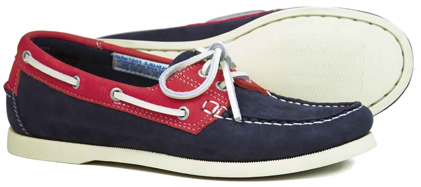 The SANDUSKY Ladies Deck Shoe in Indigo and Berry by Orca Bay features navy suede with red leather accents, non-slip white laces, and a light rubber sole—perfect for boating. Meticulous stitching highlights their craftsmanship, showcased with both top and bottom views.