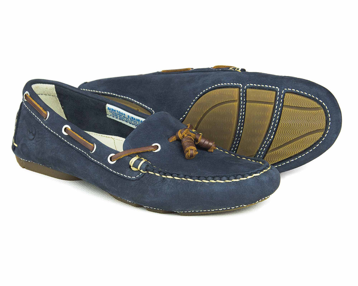 The SALE YARRAWONGA Womens Indigo Blue deck shoes by Orca Bay are stylish suede loafers with tan leather laces through eyelets, white stitching, and brown rubber sole patches for grip. One shoe is upright, while the other displays the sole pattern.