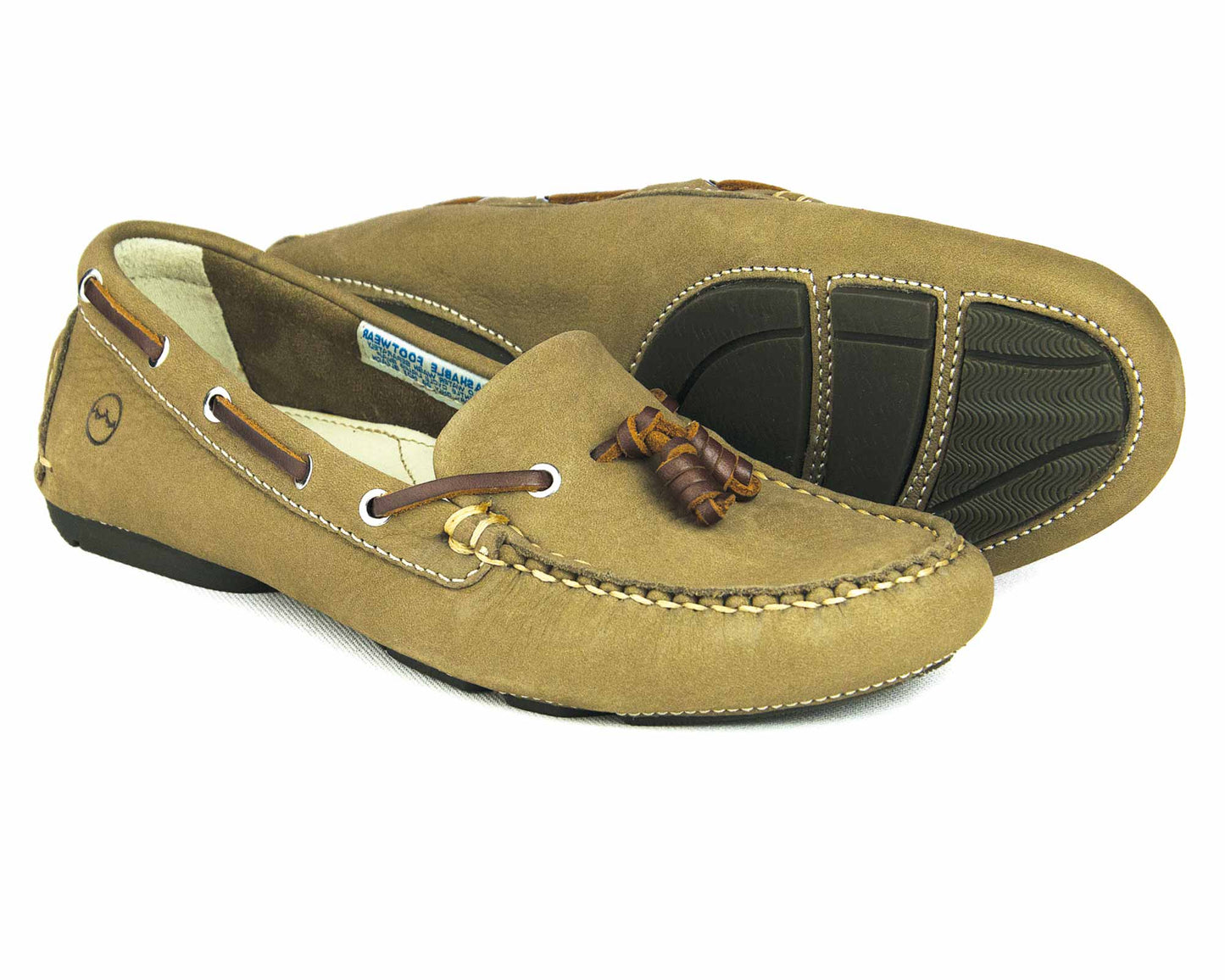 The SALE YARRAWONGA Womens Taupe Washable Deck Shoes by Orca Bay feature a nubuck finish with brown leather detailing and laces. One shoe is upright, while the other displays the rubber tread sole with black pads. These moccasins include a full leather footbed for added comfort.